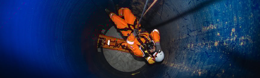 Rescue worker on ropes guided down a tunnel