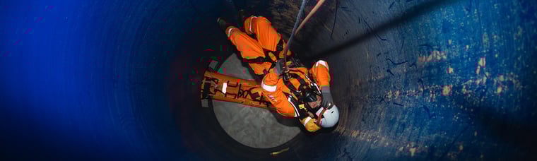 Rescue worker on ropes guided down a tunnel