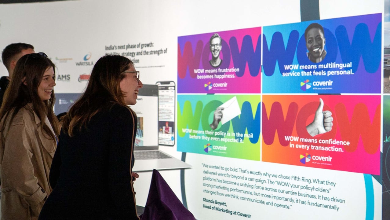 Fifth Ring employees looking at a screen the award-winning Covenir WOW campaign on the wall