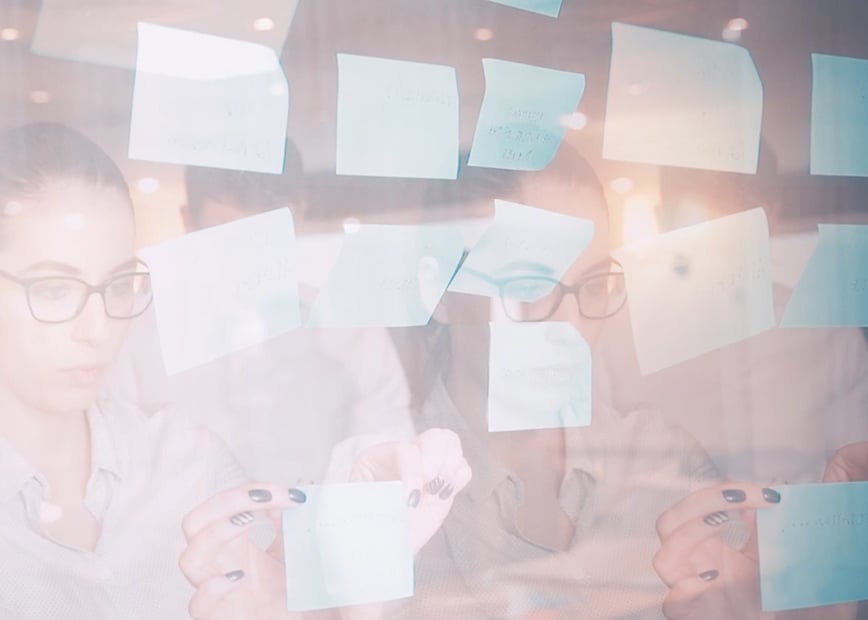 woman putting post its on clear glass